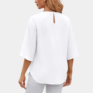 Elegant white blouse featuring fluted sleeves, a back keyhole, and a loose fit, showcasing details such as the neckline and sleeves.