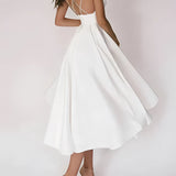 Elegant white bridal gown with a plunging neckline and spaghetti straps, designed as a one-piece garment with attention to the waist. The gown is suitable for a 2XL size, perfect for a wedding setting.
