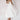 Elegant white bridal gown with a plunging neckline and spaghetti straps, designed as a one-piece garment with attention to the waist. The gown is suitable for a 2XL size, perfect for a wedding setting.