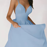 Elegant white bridal gown with a plunging neckline and spaghetti straps, featuring a fitted bodice and flowing skirt, ideal for a wedding ceremony.