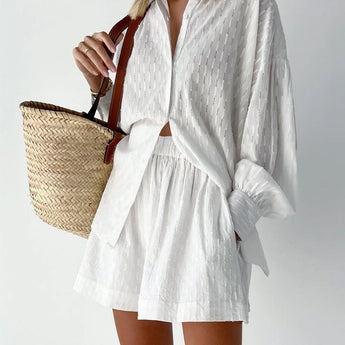 Elegant white lace blouse with sheer panels and intricate embroidery, featuring long sleeves, a high neck, and a fitted waist, shown in size Large.