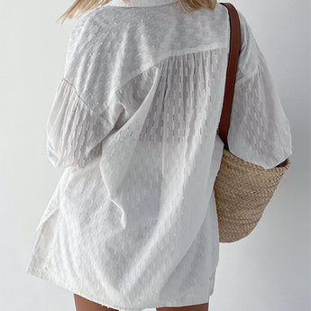 Elegant white lace blouse with sheer panels and embroidery featuring long sleeves and delicate detailing, worn by a model with visible shoulders and neck.