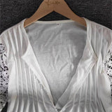 Elegant white lace sleeve V-neck blouse with intricate lace patterns, displayed on a clothes hanger.