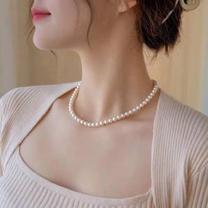 Elegant white pearl choker necklace worn by a woman, emphasizing her neck and shoulders, suitable for luxury bridal wear.