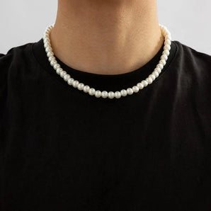 Elegant white pearl choker necklace worn around the neck, showcasing luxury short classic pearl jewelry against a grey background with a t-shirt.