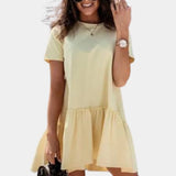 Alt text: Woman wearing a yellow XL mini dress with ruffle hem, featuring short sleeves and a casual summer style.