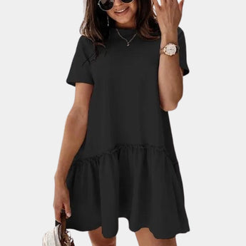 Elegant white ruffle hem mini dress with sleeveless design, featuring a fitted bodice, flared hem, and knee-length, worn by a smiling woman accessorized with a watch.