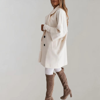 Elegant women's beige oversized wool coat featuring a high-collar design, long sleeves, and a tailored waist, showcasing a stylish winter fashion aesthetic.