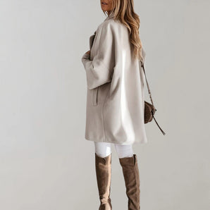 Elegant women's beige oversized wool coat with a high-collar design, featuring long sleeves and knee-length fit, suitable for winter fashion.