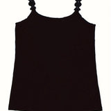 Elegant women's black sleeveless tank top with ruffled details, styled formally and chic.