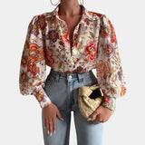 Elegant women's orange blouse featuring abstract design with sheer bell sleeves, showcasing a fashionable office chic style.