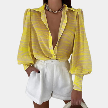 An elegant women's blouse featuring a blue abstract pattern with sheer bell sleeves, ideal for office chic style.