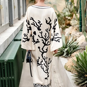 Elegant women's botanical print maxi robe in luxurious fabric, featuring long sleeves and a flowing silhouette, perfect for spa wear. The robe showcases a vibrant plant print design, emphasizing fashion and style.