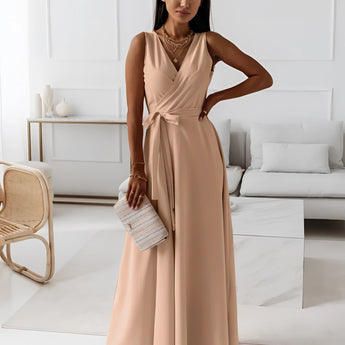 Elegant women's formal pink v-neck maxi dress featuring a sleeveless design with a fitted waist and flowing skirt, ideal for bridesmaid or evening occasions, captured in flash photography.