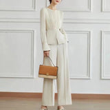 Elegant women's high-waist trouser suit and pleated blouse set in beige, featuring long sleeves and a tailored fit.