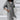 Elegant women's long hooded cardigan in gray, featuring an asymmetrical zipper design, modeled by a person wearing sunglasses. The cardigan has long sleeves and a stylish collar, providing a trench coat-like appearance, shown in size 5XL.