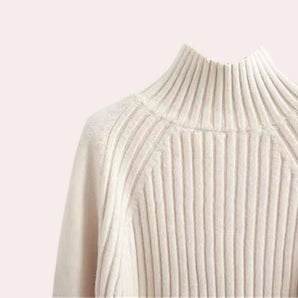 Elegant cream-colored ribbed mock neck sweater for women with long sleeves and a turtleneck design.