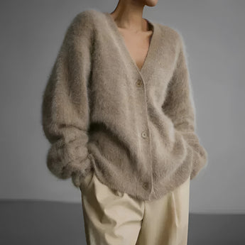 Elegant women's oversized sweater in soft beige fur, featuring long sleeves and a cozy wrap-around design ideal for winter fashion. The plush texture and woolen appearance make it perfect for keeping warm in style.