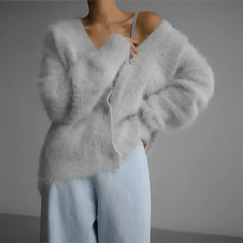 Elegant women's soft fur oversized sweater in light gray, featuring plush winter fashion design with a cozy collar and long sleeves, showcasing a luxurious and warm texture.