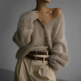 Elegant women's soft fur oversized sweater in a plush grey fabric, featuring a cozy design that highlights the shoulder and neck areas with long sleeves, perfect for winter fashion.