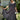 Embroidered black lace maxi dress in a bohemian style, featuring long sleeves and a fitted waist. The gown is displayed outdoors, with grass and plants in the background, creating a summery, elegant look suitable for formal occasions.