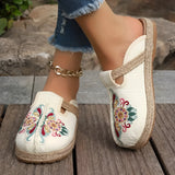 Embroidered floral espadrilles with pink and white textile design, featuring a slip-on style, shown on a person wearing them on their feet.