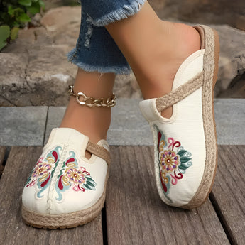 Embroidered floral espadrilles with pink and white textile design, featuring a slip-on style, shown on a person wearing them on their feet.