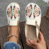 Beige embroidered floral espadrilles worn by a person in jeans, showcasing a boho chic slip-on design perfect for summer.