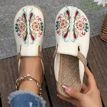 Beige embroidered floral espadrilles worn by a person in jeans, showcasing a boho chic slip-on design perfect for summer.