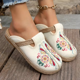 Embroidered floral espadrilles in beige with magenta accents, featuring a boho chic design, displayed on a human foot.