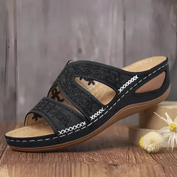 Blue embroidered floral women's sandals, comfortable summer slides on a beige background.