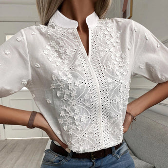 Embroidered white blouse with floral lace and eyelet detailing, featuring short sleeves and a classic neckline.