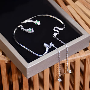 Emerald Crawler Chain Link Earrings displayed on a wooden table. The earrings feature luxurious green gemstones and an elegant chain link design, perfect for making a statement.