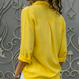 Emerald green silk blouse with long sleeves, featuring a satin finish, perfect for luxury spring fashion.