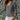 A model wearing an emerald green silk blouse with long sleeves, showcasing luxury spring fashion against a plain background.