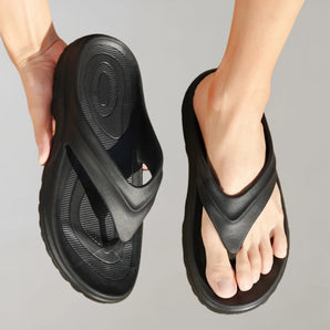 Ergonomic black flip flops featuring arch support, lightweight design, and durable synthetic rubber material.