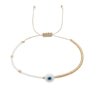 Evil Eye Gold Bead Bracelet featuring a minimalist design with an adjustable band, showcasing a central blue eye charm surrounded by gold beads.