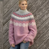 
A close-up image of a woman wearing a Fair Isle Women's Crew Neck Nordic Knit Sweater in seam pink, size 2XL. The sweater features a cozy woolen texture with a traditional Nordic pattern in pink and grey hues. The garment has long sleeves and a classic crew neck, showcasing a stylish and warm design ideal for winter fashion.
