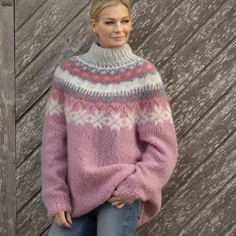 
A close-up image of a woman wearing a Fair Isle Women's Crew Neck Nordic Knit Sweater in seam pink, size 2XL. The sweater features a cozy woolen texture with a traditional Nordic pattern in pink and grey hues. The garment has long sleeves and a classic crew neck, showcasing a stylish and warm design ideal for winter fashion.