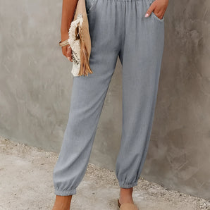 Fashionable women's chambray pants, lightweight with elastic waist, shown on model wearing a grey dress shirt, highlighting leg, joint, and waist areas.