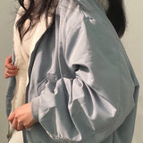 
A woman wearing a faux fur oversized cream jacket, showcasing stylish winter outerwear with prominent sleeves and a cozy collar.