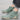 Men's white high-top designer sneakers with a sea green suede accent, featuring a stylish urban streetwear design.