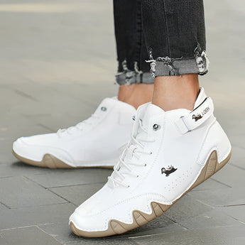 Men's white high-top designer sneakers with grey and electric blue accents, showcasing an urban streetwear style, worn by a model with visible lower legs in a sporty and fashionable setting.