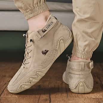 Men's white high-top designer sneakers with tan suede accents, featuring an urban streetwear style, displayed against a black background.
