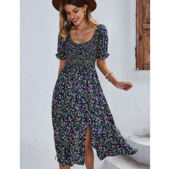 Woman wearing a marine blue floral boho maxi dress with puff sleeves and a high slit, showcasing a relaxed and happy demeanor.