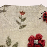 Floral & Butterfly Embroidered Women's Crew Neck Sweater featuring intricate flower and butterfly patterns on a red textile, with long sleeves and a rectangular shape.