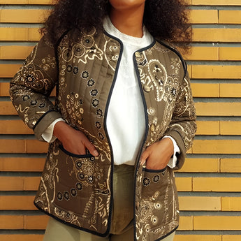 A woman wearing a floral embroidered bohemian paisley jacket, styled with long sleeves and a classic collar, suitable for spring outerwear.