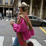 Chic women's luxury outerwear featuring a floral embroidery pink tweed jacket displayed elegantly on a hanger, showcasing its intricate detailing and sophisticated design.