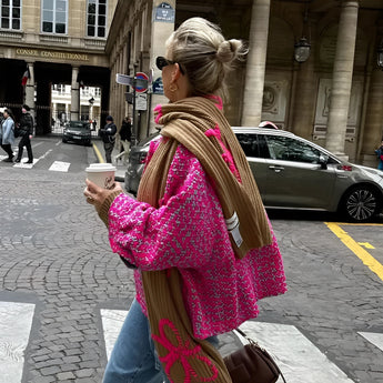 Chic women's luxury outerwear featuring a floral embroidery pink tweed jacket displayed elegantly on a hanger, showcasing its intricate detailing and sophisticated design.