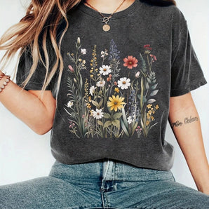 Women's charcoal gray floral graphic tee with wildflower print, styled with jeans, showcasing shoulder and arm detail.